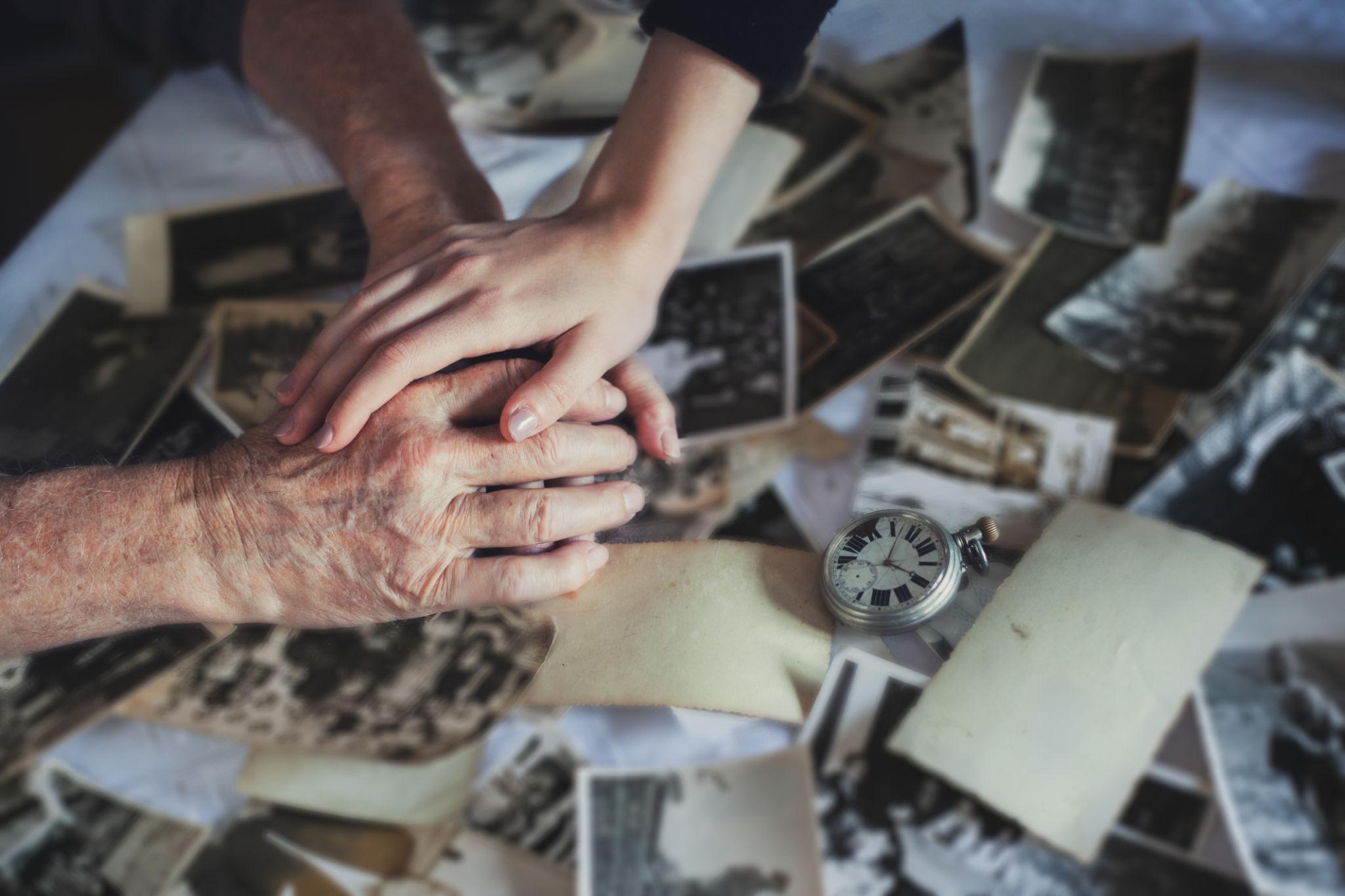 Mans de tres generacions sobre fotografies antigues